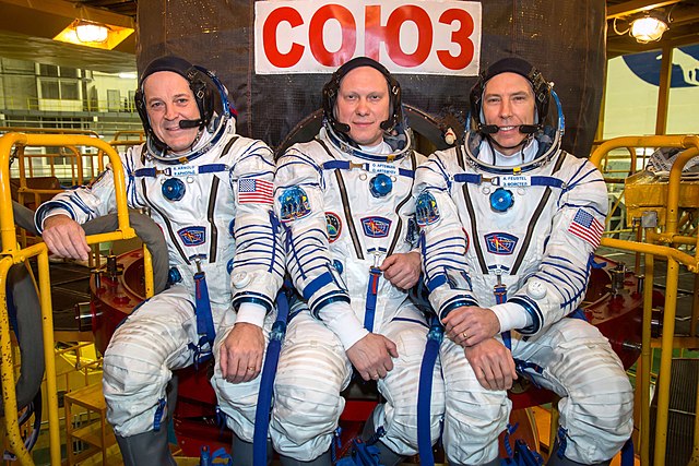 Ricky Arnold (left), Oleg Artemyev (center) and Drew Feustel (right) in front of their Soyuz spacecraft